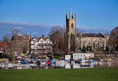 Cyclists on Sustrans National Route 4 at Hurst Park West Molesey with view across the Thames to Hampton Surrey England