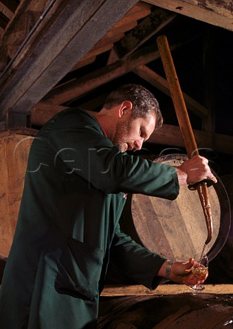 Taking a sample from a barrel of malt   whiskey using a copper valinche Old   Bushmills Distillery Bushmills County Antrim Northern   Ireland