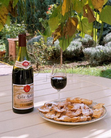 Bottle of Guigal Cte Rtie and a plate of bugnes a local speciality in garden of  Domaine Guigal Ampuis Rhne France