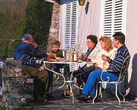 Four generations of the same French family have   aperitifs on the patio before Sunday lunch