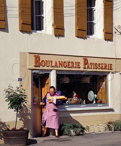 Woman coming out of Boulangerie with baguettes PulignyMontrachet Cte dOr France