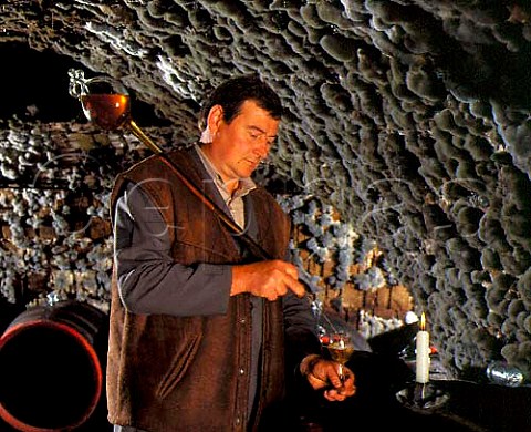 Gyula Borsos filling a tasting glass with wine    taken from barrel with a pipette  in the ancient   mouldcovered cellars of Tokaj Kereskedhz Tolcsva   Hungary  Tokaji