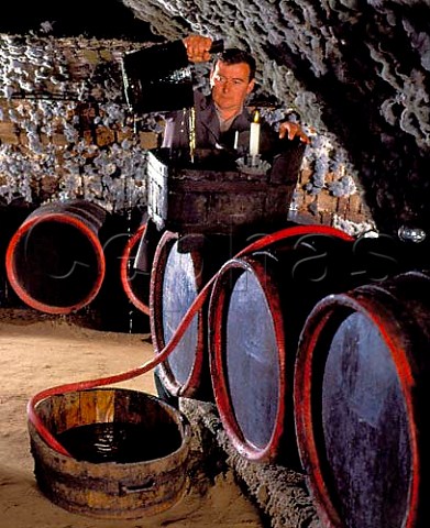 Gyula Borsos racking wine in the traditional manner   in the ancient mouldcovered cellars of   Tokaj Kereskedhz Tolcsva Hungary  Tokaji