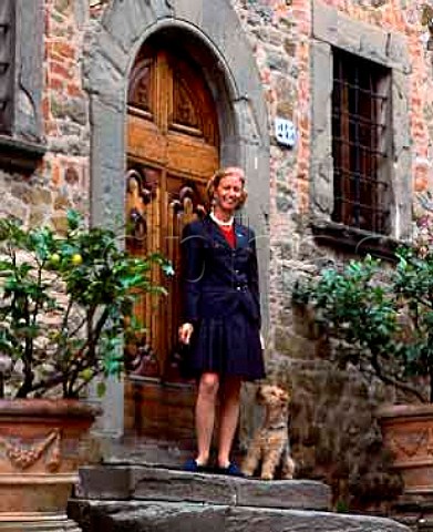Giovannella Stianti Mascheroni with her dog at the entrance to the offices of Castello di Volpaia in the medieval hamlet of Volpaia Tuscany Italy  Chianti Classico