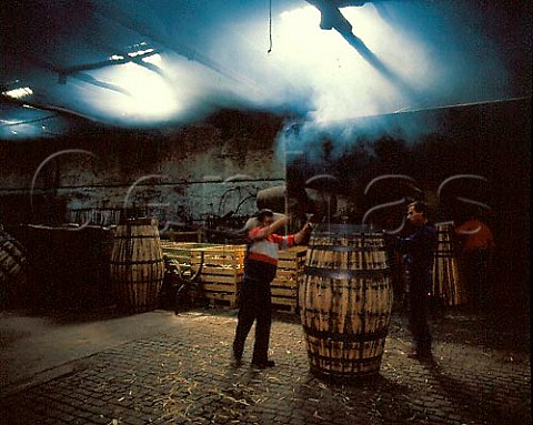 Tightening the hoops on a barrel in the cooperage in   one of Ferreiras lodges at Vila Nova de Gaia The   barrels are made of Portuguese oak
