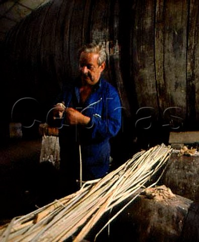 Wrapping pieces of bullrush around bungs to keep   them tight in the barrels Bodegas Muga Haro Spain   Rioja