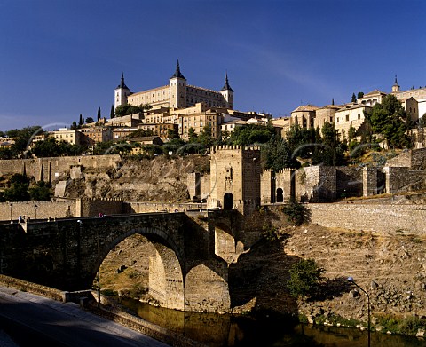 The Puente de Alcantara constructed in the 10th   century spans the Tajo River with the Alcazar above   Toledo CastillaLa Mancha Spain