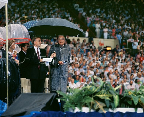 Billy Graham with umbrella held by Richard Bewes  8 July 1989 Wembley Stadium London England