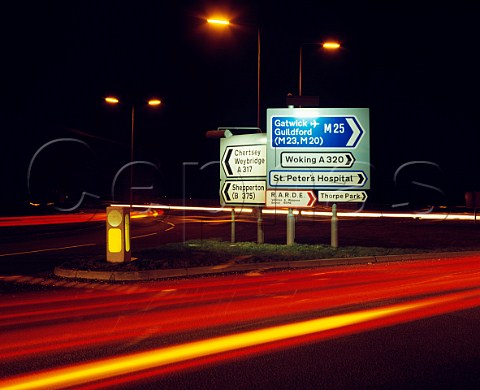 Road signs on roundabout above the M25 at Chertsey Surrey England
