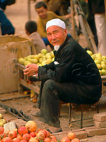 Selling apples and pomegranates in Turfan market   Xinjiang China