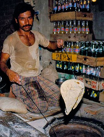 Taking chapati out of tandoori oven Lahore   Pakistan