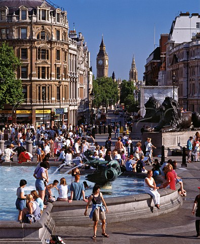 Crowds gathered around the Trafalgar Square fountains on a hot summers day  London England