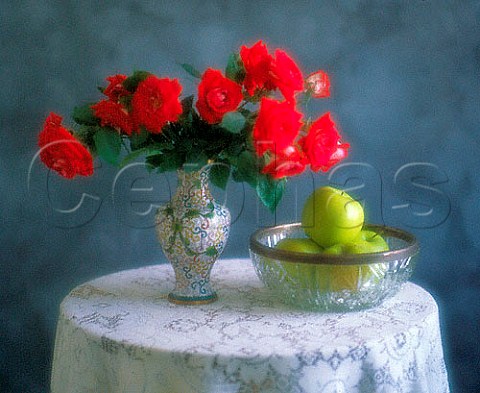Vase of roses and bowl of apples