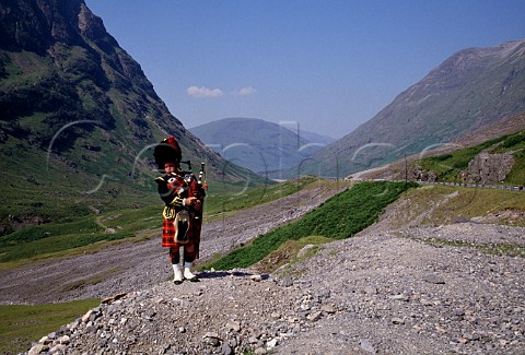 Piper playing bagpipes in Glencoe Highlands  Scotland