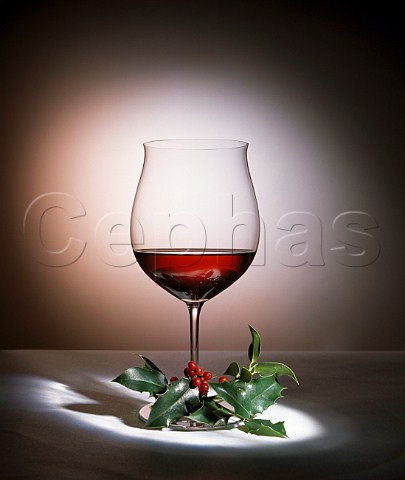 Christmas Glass of red wine with sprig of holly
