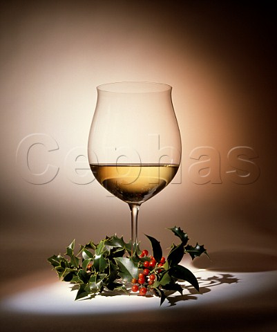 Christmas Glass of white wine and sprig of holly