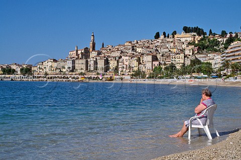 Elderly woman sitting on chair on beach at Menton  AlpesMaritimes France   CtedAzur