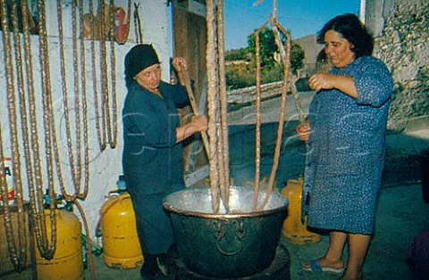 Confectionary Making Sojouko  dipping   strings of almonds into thickened grape   juice  Arsos Cyprus Greece