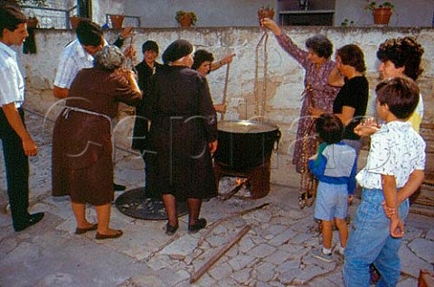 Making Siousiouko dipping strings of almonds in thickened grape juice  Arsos Cyprus Greece