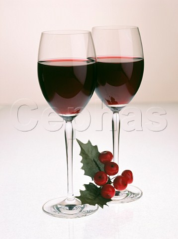 Two glasses of red wine with sprig of holly  