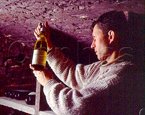 Christophe Roumier examines a bottle of   CortonCharlemagne 1990 in the cellars of   Domaine Georges Roumier ChambolleMusigny   Cte dOr France