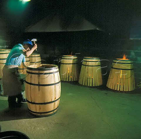 Tightening the hoops on a barrel at   Tonnellerie Lasserre Vertheuil Gironde France