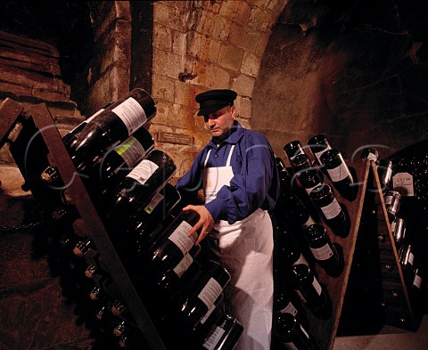 JeanPierre Girondin Chef de Caves working   on Jeroboams in pupitres in the remains of the   13th century chapel of Saint Niaise Abbey   which form part of the cellars of   Champagne Taittinger Reims Marne France