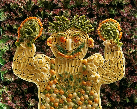 Pasta  Assorted pasta forming the shape of a man   with a background of Lollo Rosso Lettuce