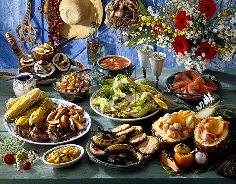 Summer Table With barbecued steaks sweetcorn  bananas etc green salad fresh fruit salad in a  pineapple shell etc