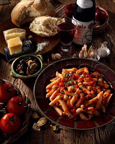 Italy Penne with chickpeas and tomatoes and a   bottle and a glass of Barolo