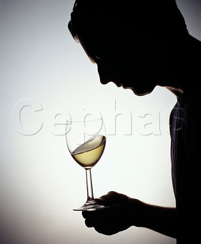 Man swirling white wine