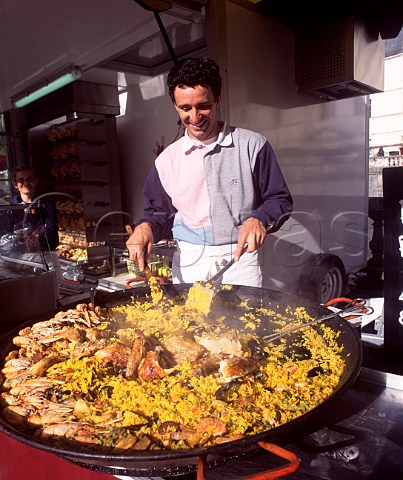Cooking a giant paella in the market at Brantme  Dordogne France