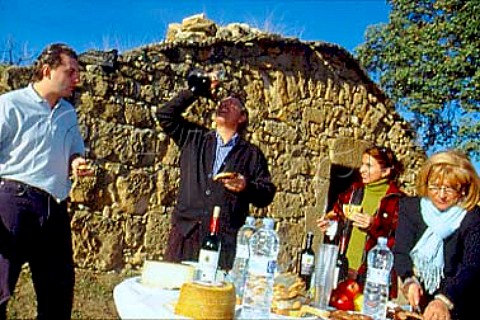 Pons family  Friends Makers of Belazu  Olive Oil enjoying an early morning  Catalonian breakfast of bread sausages  fruit and cheese with wine in traditional  flask  Spain