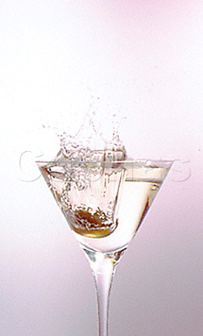 Dropping an olive into a Dry Martini