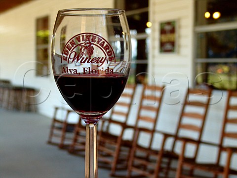 Eden Vineyards Winery glass with winery behind   Alva Florida USA