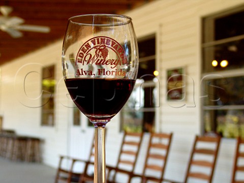 Eden Vineyards Winery glass with winery behind   Alva Florida USA