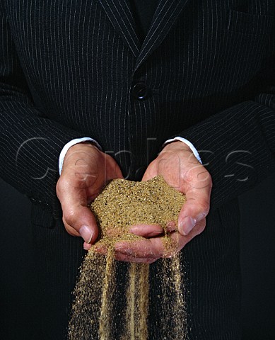 Hands of a businessman with sand pouring through