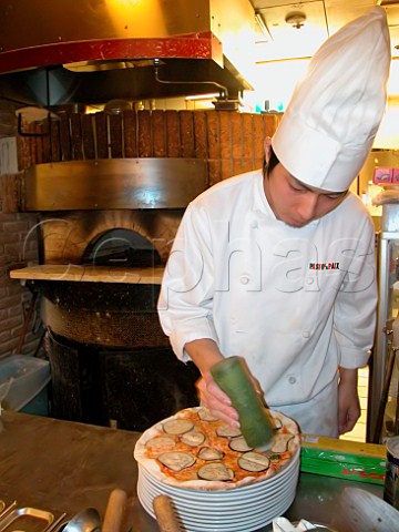 Chef preparing an aubergine pizza in an Italian   style restaurant  Tokyo Japan