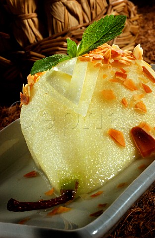 Dessert pear in white wine with toasted almond   flake and mint topping