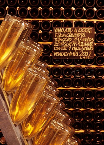 Bottles of sparkling wine in pupitre in   the cellars of Cavalleri Erbusco   Lombardy Italy Franciacorta