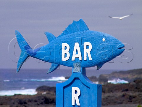 Fish shaped Bar sign with coast in background   Lanzarote Canary Islands Spain