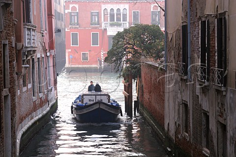 Delivery boat on canal in Venice Italy