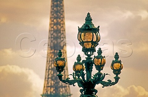 Ornate street lamps on Pont Alexandre III at sunset  with Eiffel Tower in background Paris France
