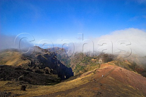 Walkers in the mountains at Pico do Arieiro with   the Atlantic Ocean in the distance Madeira Portugal