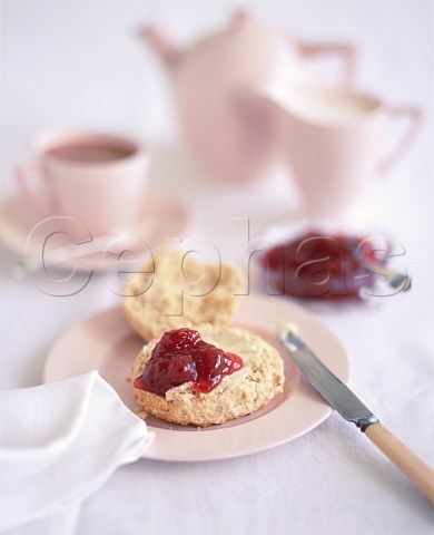 Buttered scone with strawberry jam and afternoon tea