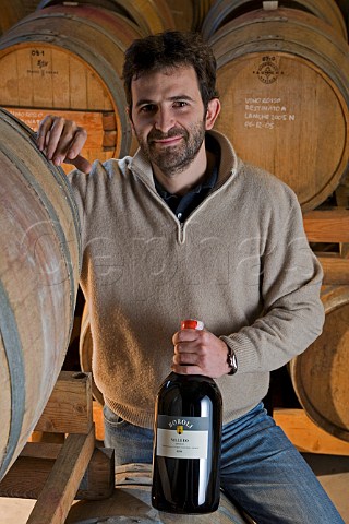 Silvano Boroli with bottle of Villero Barolo in   cellar of Vini Boroli  Madonna di Como near Alba   Piemonte Italy