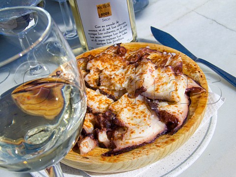 Pulpo a la Gallega with a glass and bottle of Vega  de Yuco Malvasia seco white wine in a seafront tapas  bar