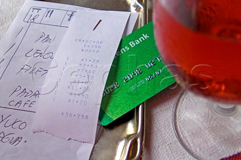 Spanish restaurant bill with bank card and  glass of   rose wine