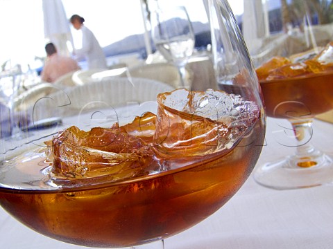 Glasses of Ron Miel liqueur on ice on outdoor   alfresco restaurant table