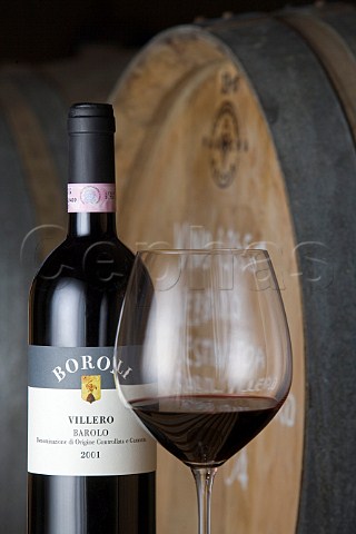 Glass bottle and barrel of Villero Barolo in cellar   of Vini Boroli Madonna di Como near Alba Piemonte   Italy